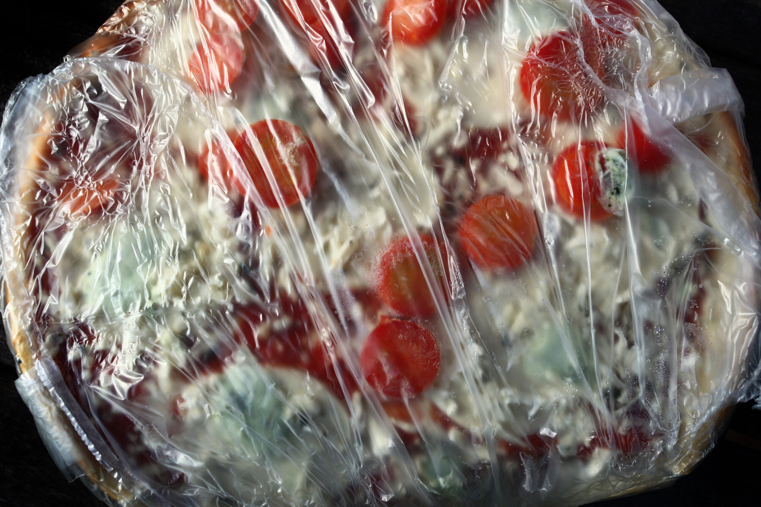 FILED - 18 May 2014, Bavaria, Kaufbeuren: A frozen ready-to-eat pizza wrapped in plastic film. Dema...