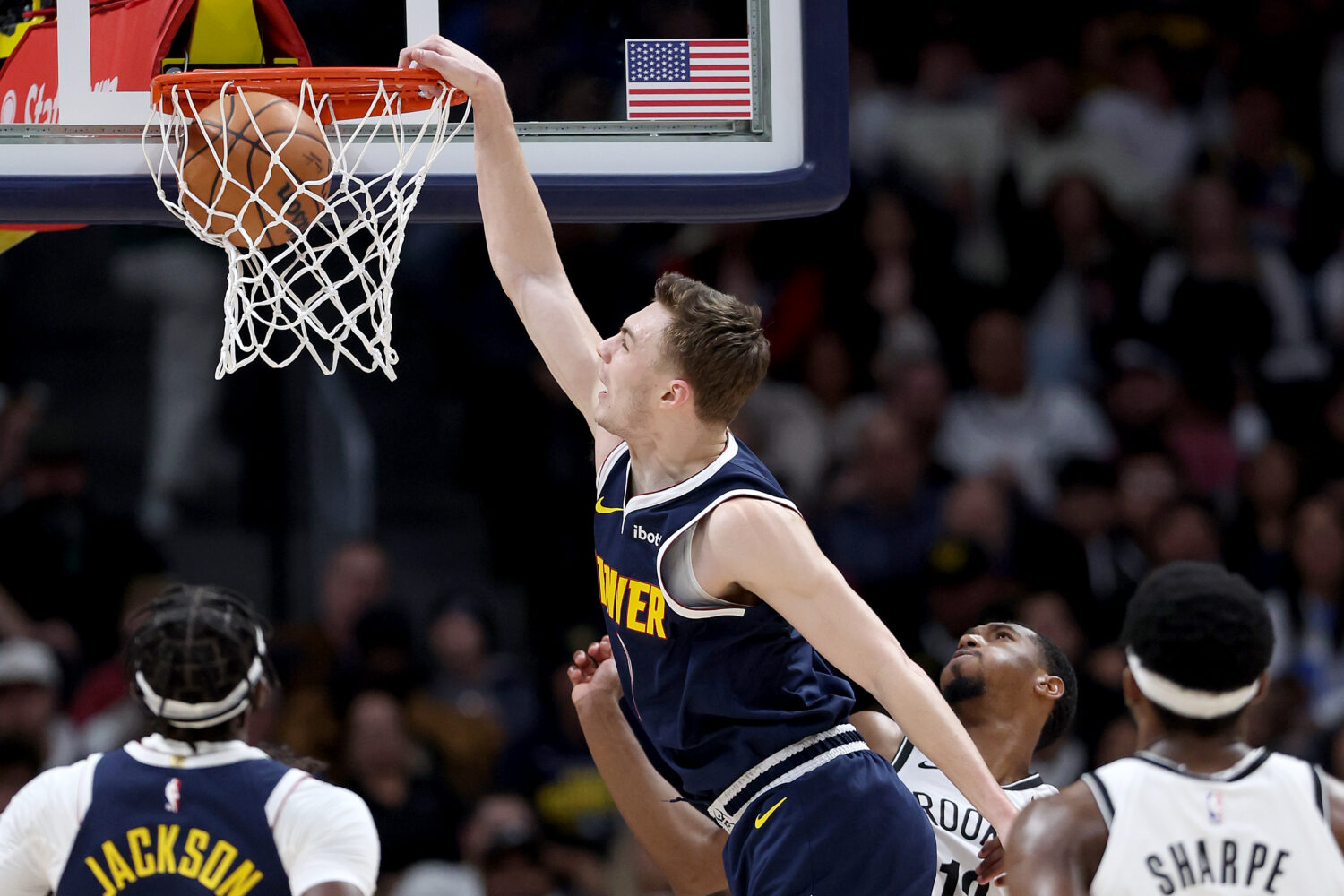 DENVER, COLORADO - DECEMBER 14: Christian Braun #0 of the Denver Nuggets dunks on Armoni Brooks #13...