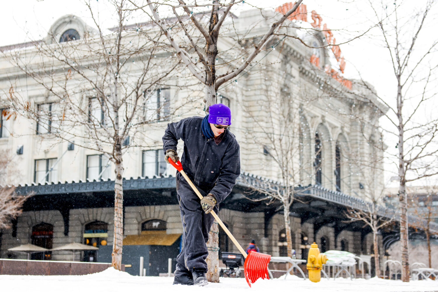 DENVER, CO - FEBRUARY 22: A Downtown Denver Business Improvement District employee shovels the side...