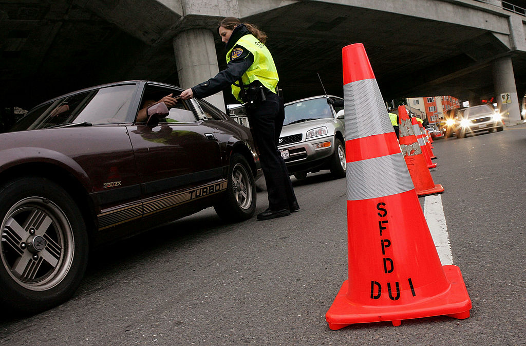 SAN FRANCISCO - DECEMBER 26: A San Franciso police officer checks a drivers license at a sobriety c...