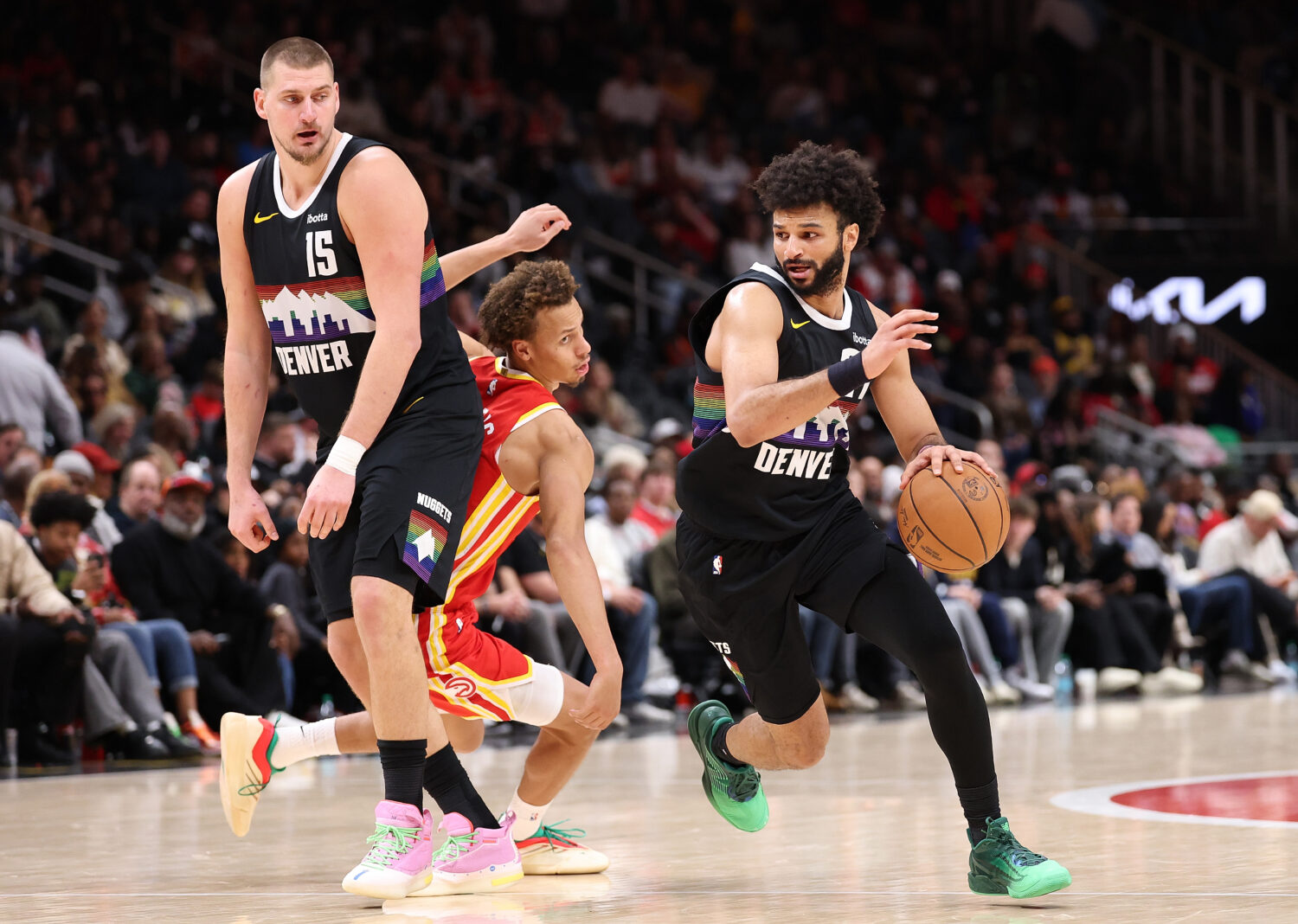ATLANTA, GEORGIA - DECEMBER 05:  Jamal Murray #27 of the Denver Nuggets drives around Nikola Jokic ...