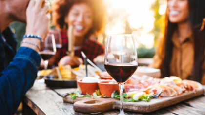 Happy family having barbecue party in backyard - Young friends celebrating at dinner drinking red w...