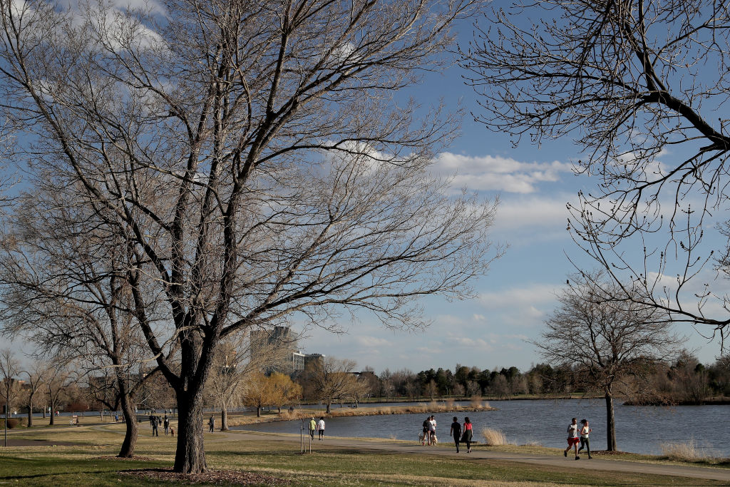 DENVER, COLORADO - APRIL 08: Walkers take advantage of the pathway around the lake at Sloan's Lake ...