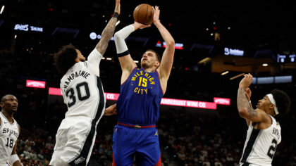 SAN ANTONIO, TX -APRIL 12: Nikola Jokic #15 of the Denver Nuggets shoots over Julian Champagnie #30...