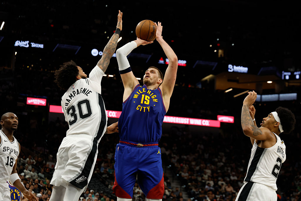 SAN ANTONIO, TX -APRIL 12: Nikola Jokic #15 of the Denver Nuggets shoots over Julian Champagnie #30...