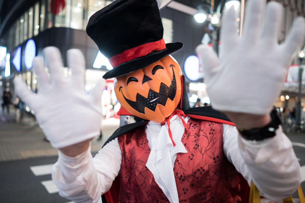 TOKYO, JAPAN - OCTOBER 31: A man wearing a costume waves near Shibuya Crossing during Halloween on ...