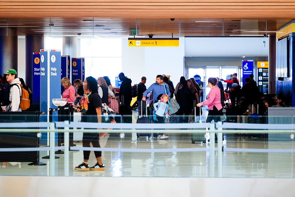 DENVER, COLORADO - NOVEMBER 8: People walk through Denver International Airport on November 8, 2025...
